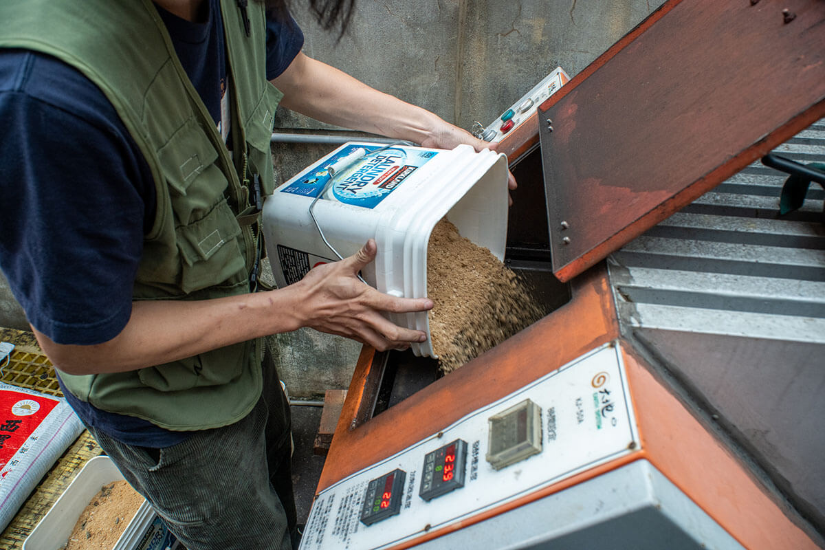 拼圖喵的工作人員將貓糞便及天然貓砂倒入機器中，約四小時可處理成堆肥。